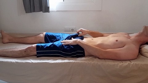 Bel ragazzo attraente si stuzzica attraverso i suoi pantaloncini dopo la palestra